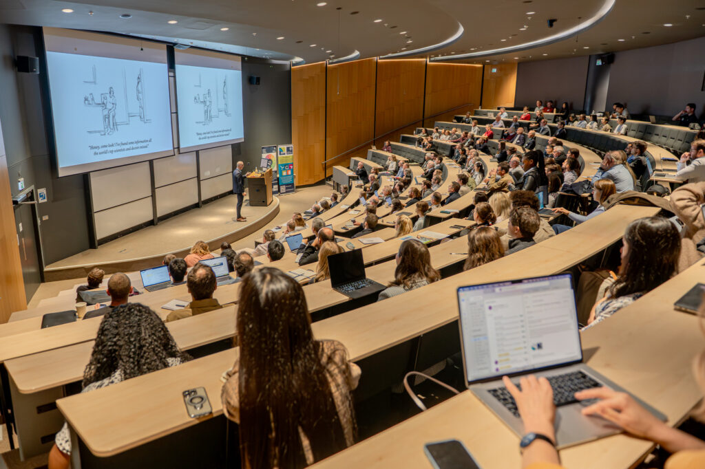 Speaker and audience in a large lecture theatre